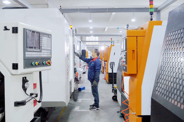 Fabrikarbeiter -Betriebsmaschinerie in einer industriellen Umgebung, umgeben von verschiedenen Arten von Elektrowerkzeugen wie Abbruchhämmern, Rotary -Hämmer und Jackhämmern sowie Wechselstrom- und Schnurmodelle.
